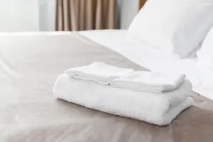 Hotelbett mit Kissen und Handtüchern
