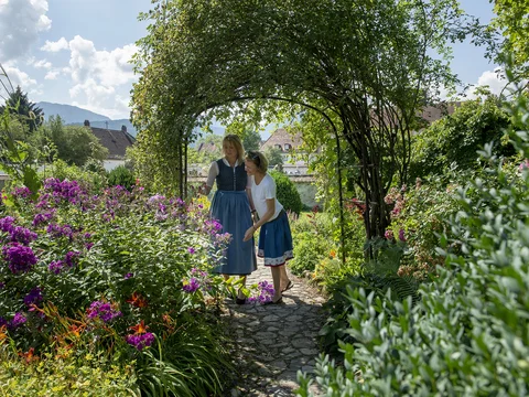 zwei Frauen erkunden die Kräuter im Meditationsgarten