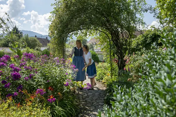 zwei Frauen erkunden die Kräuter im Meditationsgarten