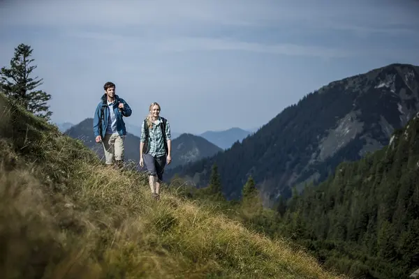 Paar wandert auf schmalem Bergpfad