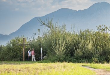 Paar steht an einer Stele des Benediktuswegs
