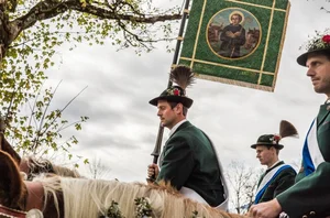 drei Vorreiter mit Standarte bei der Leonhardifahrt