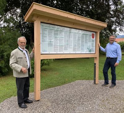 Erwin Pecho und Toni Ortlieb vor der neuen Zeittafel im Gemeindepark