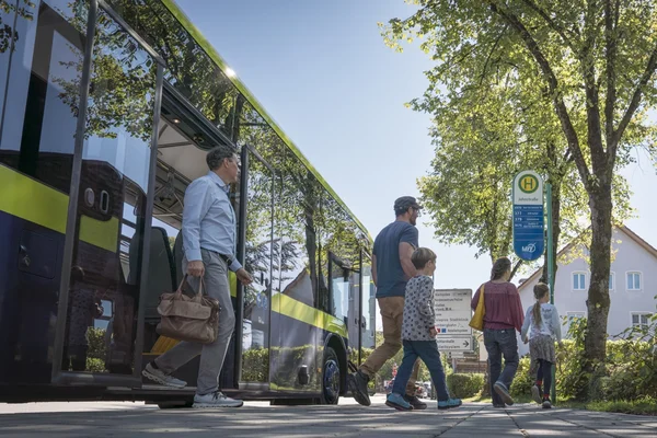 mehrere Fahrgäste steigen aus einem MVV-Bus aus
